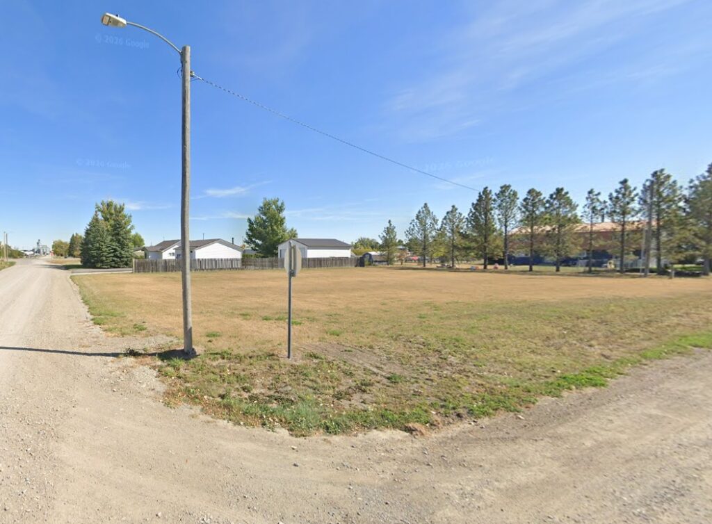 Google Street View photo taken from an intersection of vacant land consisting of mowed grass